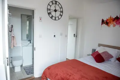a bedroom with a bed and a clock on the wall at Trinity, Central Cambridge Flat in Cambridge