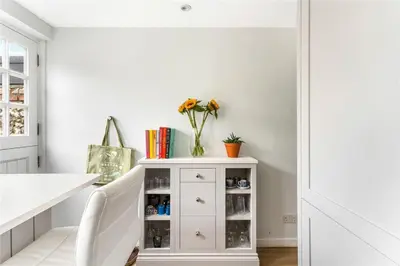 a white cabinet with a vase of flowers on it at Cottage, Central Saffron Walden, Garden, Little Braybrooke in Saffron Walden