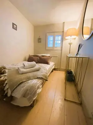 a bedroom with a bed and a table with a lamp at Beautiful Immaculate Aldeburgh cottage, free parking, sunny outdoor space, dog friendly - perfect for Spring seaside escapes in Aldeburgh