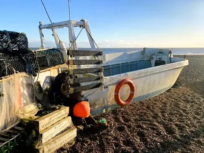 a boat sitting on the shore of the beach at Beautiful Immaculate Aldeburgh cottage, free parking, sunny outdoor space, dog friendly - perfect for Spring seaside escapes in Aldeburgh