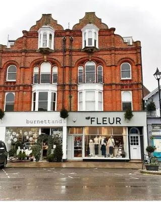 a large brick building with a store in front of it at Beautiful Immaculate Aldeburgh cottage, free parking, sunny outdoor space, dog friendly - perfect for Spring seaside escapes in Aldeburgh