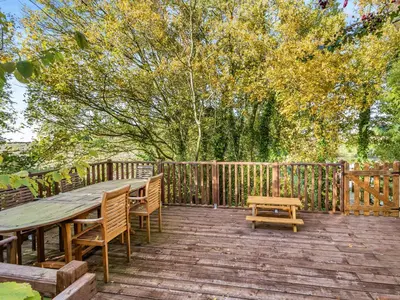 a wooden deck with a wooden table and benches at Lion House- Uk45705 in Brinkley