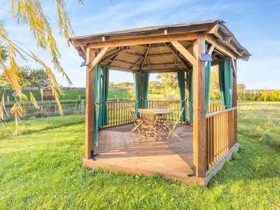 a wooden gazebo with a table and chairs at Beavers- Uk45706 in Cambridge