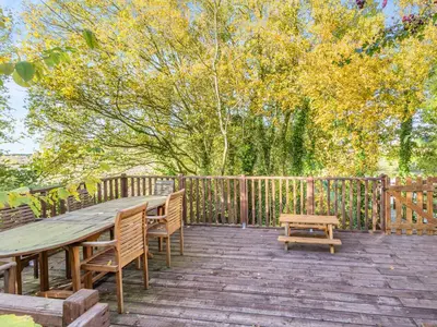 a wooden deck with a wooden table and benches at Beavers- Uk45706 in Cambridge