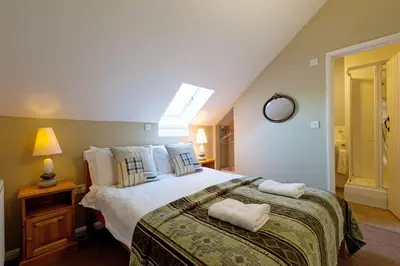 a bedroom with a bed with two towels on it at Marshlands House, Sleeps 16 - Country barn with hot tub in Woodbridge