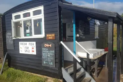 a black tiny house with a sign on the door at Marshlands House, Sleeps 16 - Country barn with hot tub in Woodbridge