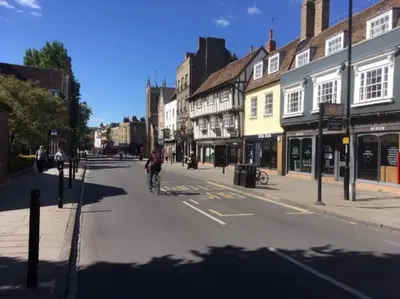 a person riding a bike down a city street at Bright & spacious first floor apartment Cambridge in Chesterton