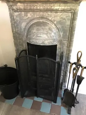 a fireplace with a black hearth and some scissors at Bright & spacious first floor apartment Cambridge in Chesterton