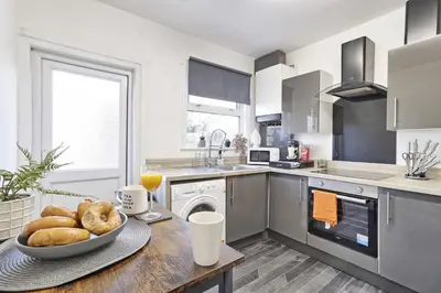 a kitchen with a table with a bowl of bread on it at Beautiful Spacious four bedroom house with parking for 2 cars, 5 minute walk to southend station in Southend-on-Sea