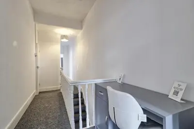 a staircase with a blue desk and a white chair at Beautiful Spacious four bedroom house with parking for 2 cars, 5 minute walk to southend station in Southend-on-Sea