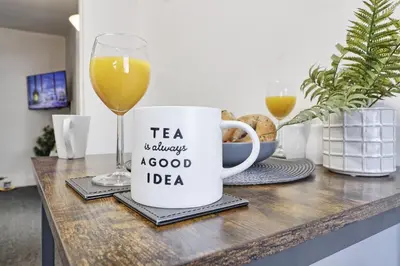 a cup of coffee and a glass of wine on a counter at Beautiful Spacious four bedroom house with parking for 2 cars, 5 minute walk to southend station in Southend-on-Sea
