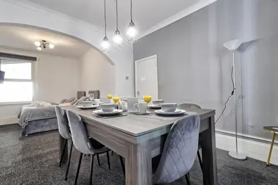 a dining room with a wooden table and chairs at Beautiful Spacious four bedroom house with parking for 2 cars, 5 minute walk to southend station in Southend-on-Sea