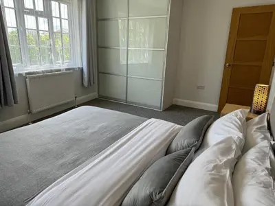 a bedroom with a large bed with pillows on it at Luxury Apartment in Letchworth in Letchworth