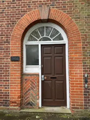 a brown door and a window in a brick building at Luxury Apartment in Letchworth in Letchworth