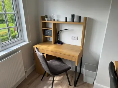 a desk with a lamp and a chair next to a window at Luxury Apartment in Letchworth in Letchworth