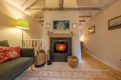 a living room with a fireplace and a couch at A fairy-tale luxurious cottage - The Tea Caddy in Colchester