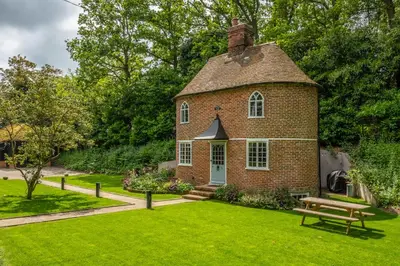 an old brick house with a green lawn at A fairy-tale luxurious cottage - The Tea Caddy in Colchester