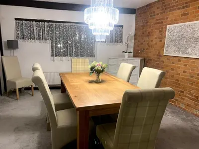 a dining room table with chairs and a vase of flowers at Duchess Apt 2 Modern 3Bedroom Apartment in Colchester Ideal for Long Stays, Relocations, Contractors, Secure Parking, WIFI in Colchester