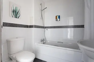 a bathroom with a toilet and a tub and a sink at Jade Apartments Basildon in Basildon