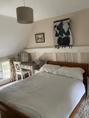a bedroom with a large white bed and a desk at Mulleys Cottage (Bed and Breakfast) in Westleton