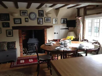 a living room with a table and a fireplace at Mulleys Cottage (Bed and Breakfast) in Westleton