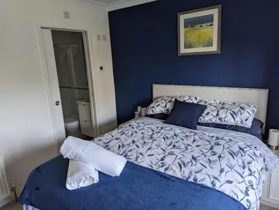 a bedroom with a bed with a blue wall at Little Barham B&B in Wethersfield