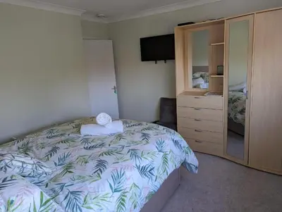 a bedroom with a bed and a dresser and a television at Little Barham B&B in Wethersfield