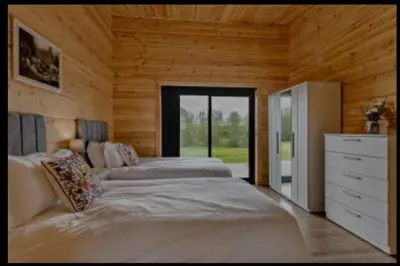 a bedroom with two beds and a dresser at Meadow Valley Lodge 2 in Hintlesham