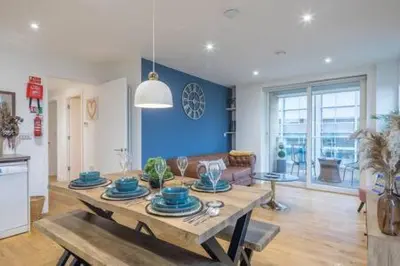 a living room with a table with blue dishes on it at Luxe Cambridge Station Flat with Terrace in Cambridge