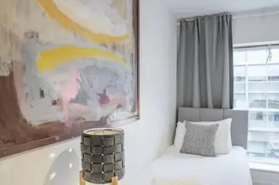 a room with a painting and a bed with a pillow at Luxe Cambridge Station Flat with Terrace in Cambridge