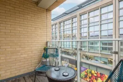 a balcony with a table and chairs and a window at Luxe Cambridge Station Flat with Terrace in Cambridge