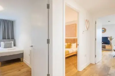 a room with a bedroom with a bed and a mirror at Luxe Cambridge Station Flat with Terrace in Cambridge