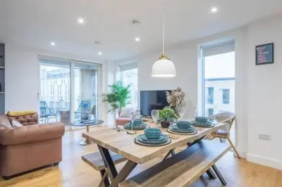 a living room with a table and a couch at Luxe Cambridge Station Flat with Terrace in Cambridge