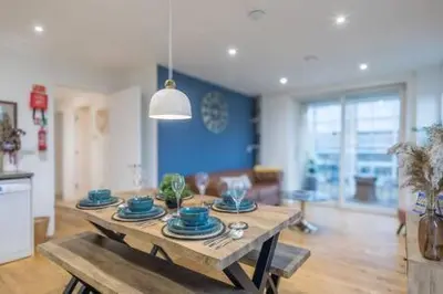 a living room with a table with blue dishes on it at Luxe Cambridge Station Flat with Terrace in Cambridge