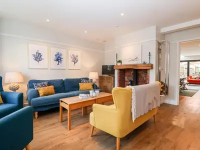 a living room with a blue couch and a table at Fawcett Cottage in Aldeburgh