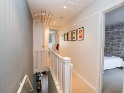 a white staircase in a bedroom with a bed at Fawcett Cottage in Aldeburgh