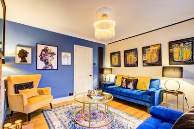 a blue living room with a couch and a table at Chic Cottage Fireplace Patio Pet Train Stn in Wivenhoe