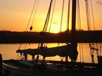 a boat sitting in the water at sunset at Chic Cottage Fireplace Patio Pet Train Stn in Wivenhoe