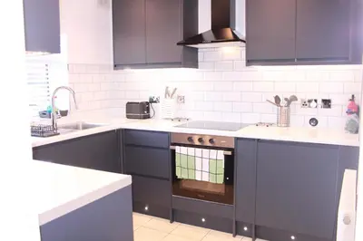 a kitchen with blue cabinets and a sink at Stunning 3 bedroom apartment in Harlow, Essex in Harlow