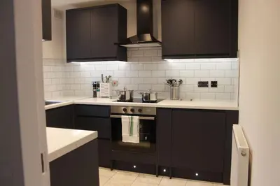 a kitchen with black cabinets and a stove at Stunning 3 bedroom apartment in Harlow, Essex in Harlow