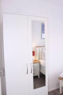 a white door with a mirror in a bedroom at Stunning 3 bedroom apartment in Harlow, Essex in Harlow