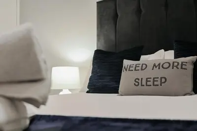 a bed with a need more sleep pillow on it at Hurrell House in Boreham