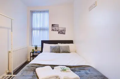 a bedroom with a bed with two towels on it at Modern 5 Bed House with Parking in Colchester