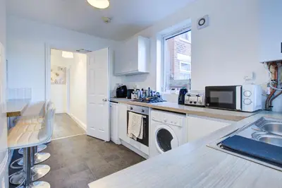 a kitchen with a sink and a dishwasher at Modern 5 Bed House with Parking in Colchester