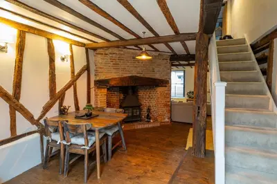 a dining room with a table and a fireplace at Charming 2 bedroom property in Bury Saint Edmunds