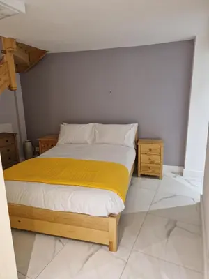 a bedroom with a bed with a yellow blanket at The Old Hay Store, Ely in Ely