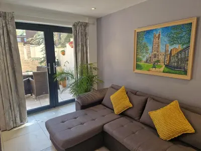 a living room with a couch and a painting on the wall at The Old Hay Store, Ely in Ely