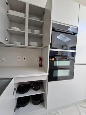 a kitchen with white cabinets and white dishes at The Old Hay Store, Ely in Ely