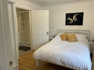 a bedroom with a white bed and a shower at Modern The Mews Apartment in Bury Saint Edmunds