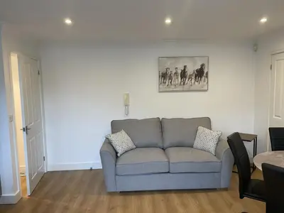 a living room with a couch and a picture on the wall at Modern The Mews Apartment in Bury Saint Edmunds